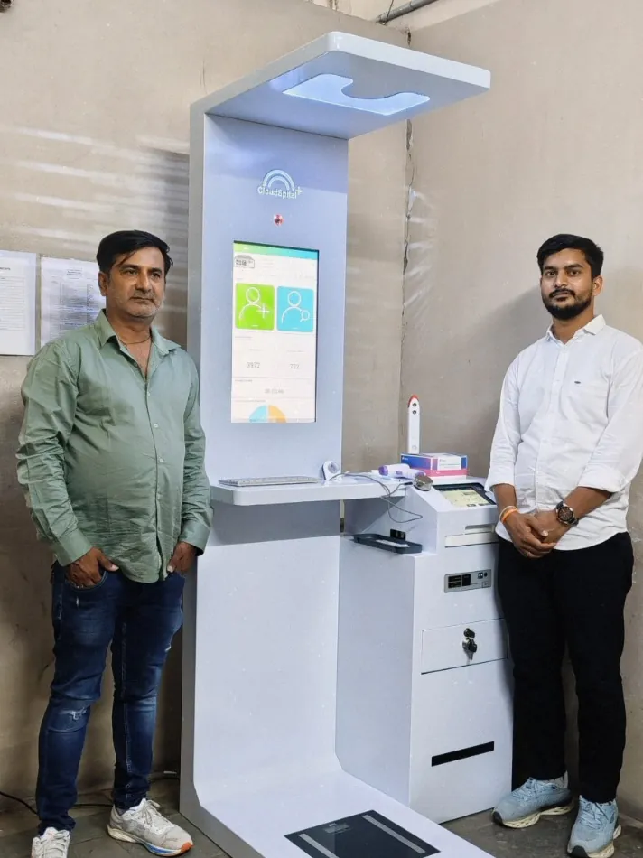 Two men standing beside a Cloudspital Health ATM at a government site in Hyderabad